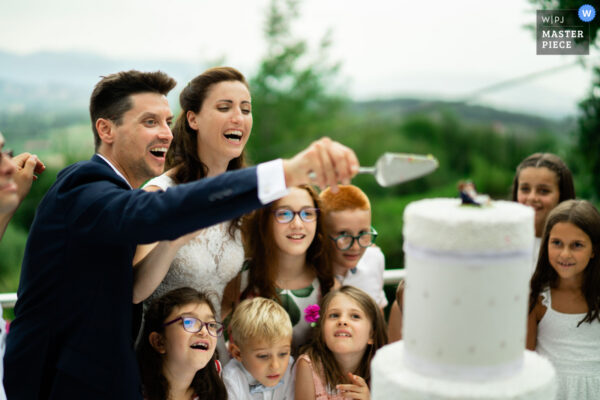 Gli sposi condividono il momento del taglio della torta con i loro piccoli invitati